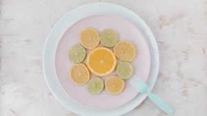 Top view of citrus slices on ceramic plates, showcasing lime and orange artistry.